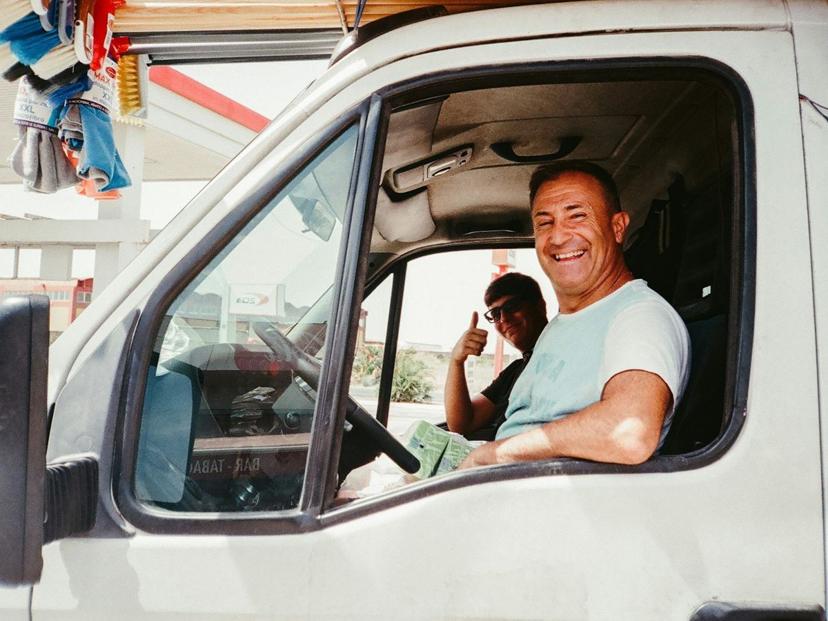 A smiling van driver in the cab.